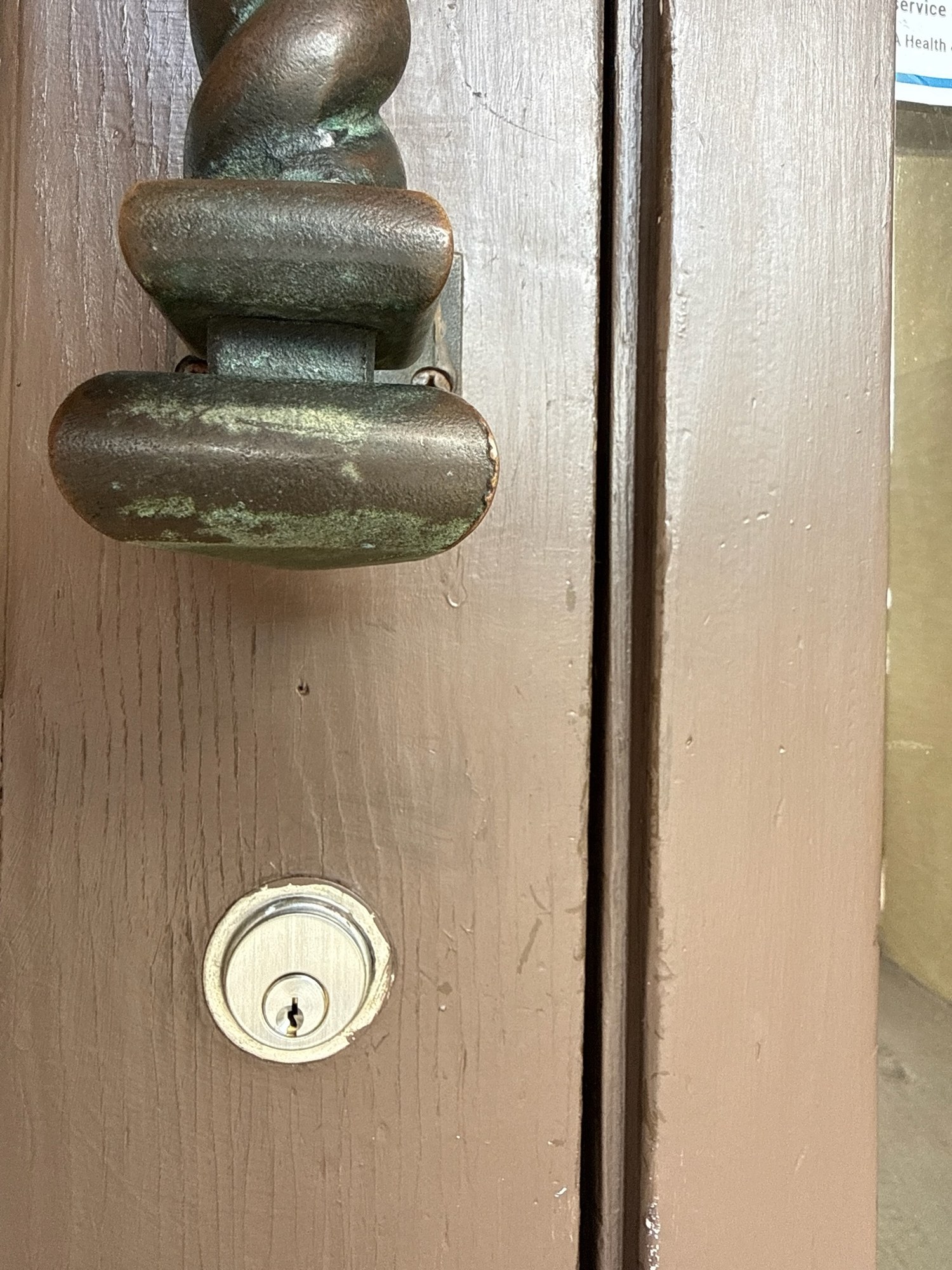 Rim cylinder rekey below a cast-iron thumb-latch handle set on a timber commercial door